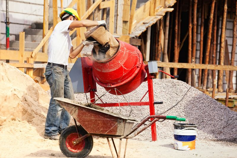 concrete worker mixing concrete with a concrete mixer