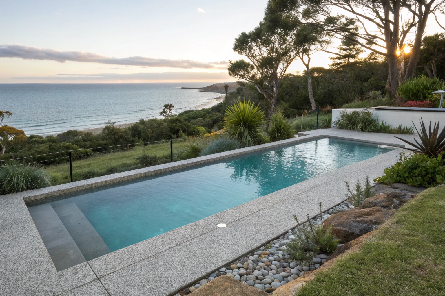 Exposed aggregate concrete pool surround at a coastal residential home